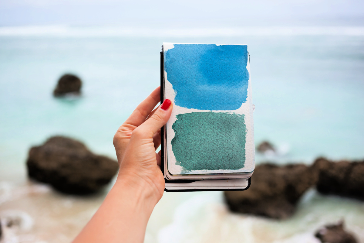 View of watercolour paint in sketchbook on beach in Bali